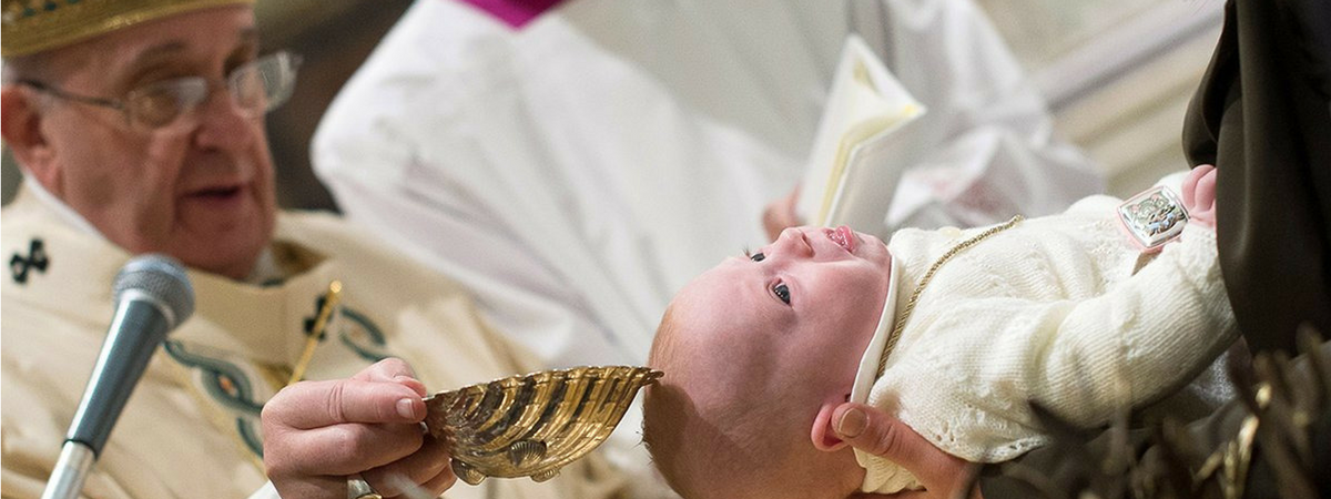 Pope Francis baptizes a baby.